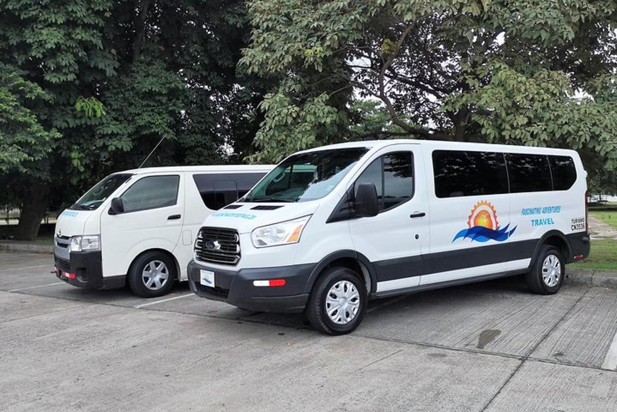 duas vans brancas estacionadas em um estacionamento