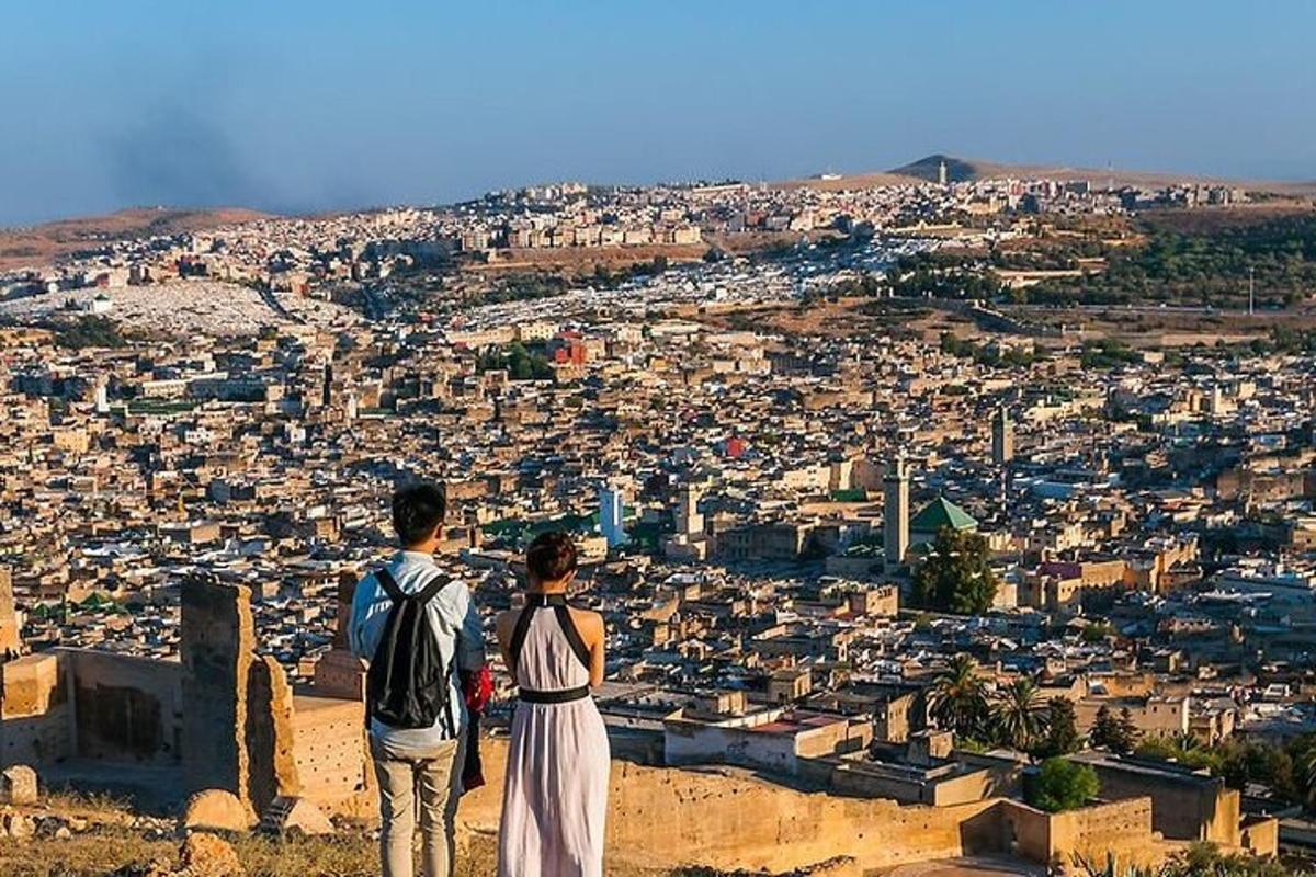 شخصان يقفان على قمة تل ينظران إلى المدينة