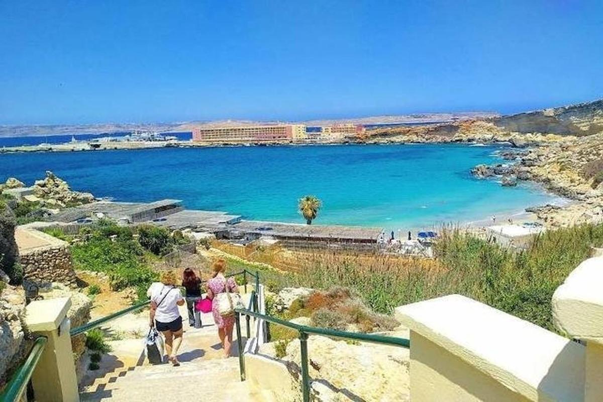 a group of people walking down the stairs to a beach