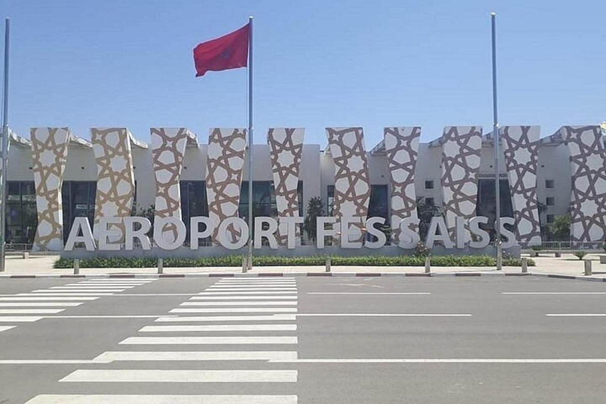 a large building with a red flag on a street