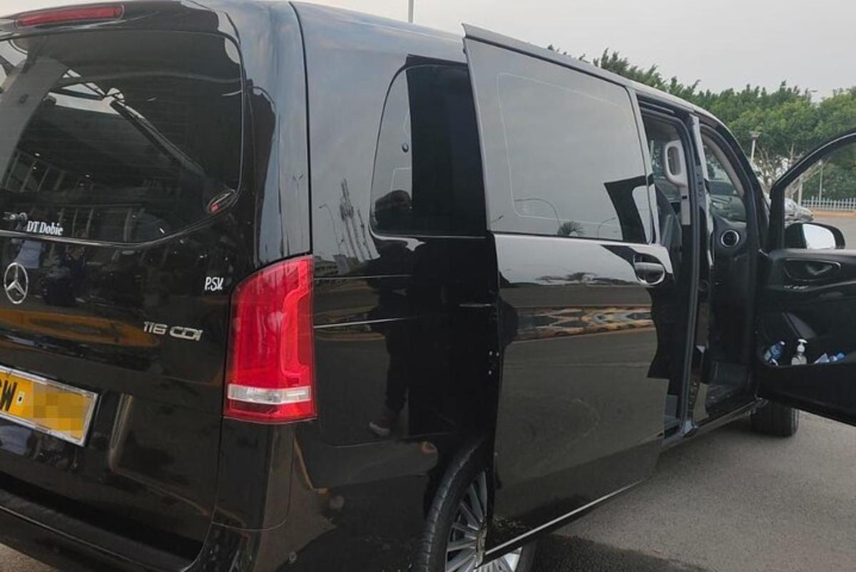 sebuah van hitam dengan pintunya terbuka di tempat letak kereta