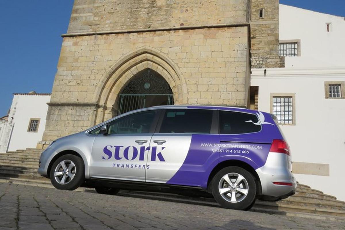 Una camioneta morada y blanca estacionada frente a un edificio