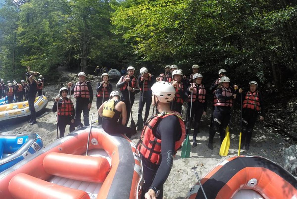 a group of people standing next to a raft on a river