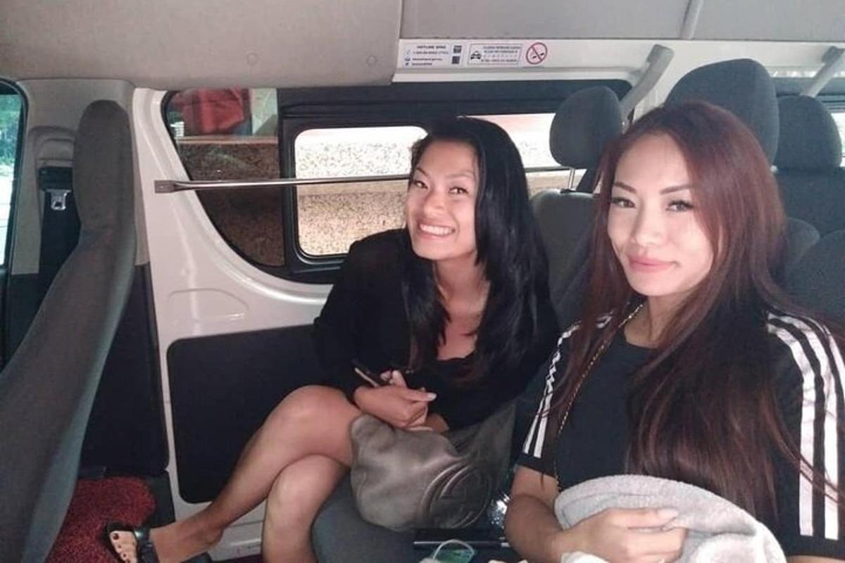 two women sitting in the back of a car