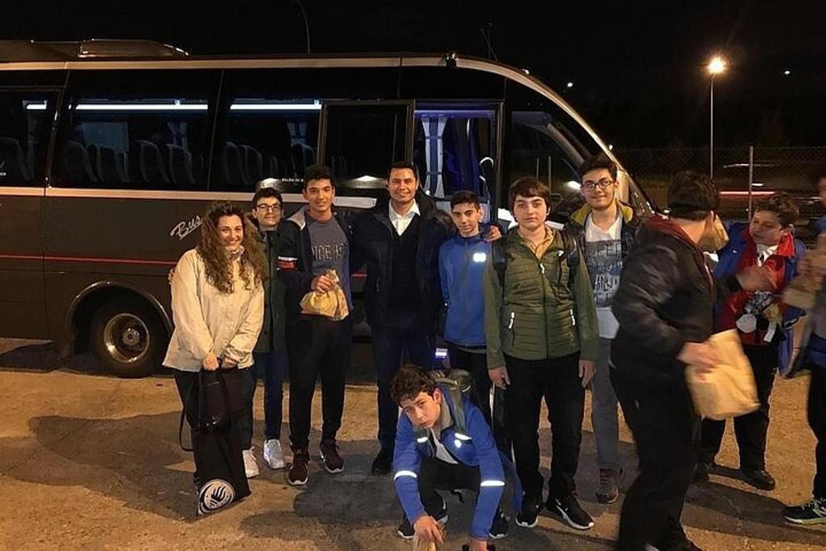 sekelompok orang berdiri di depan bus