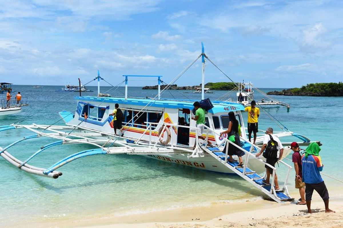 a group of people getting on a boat on the beach