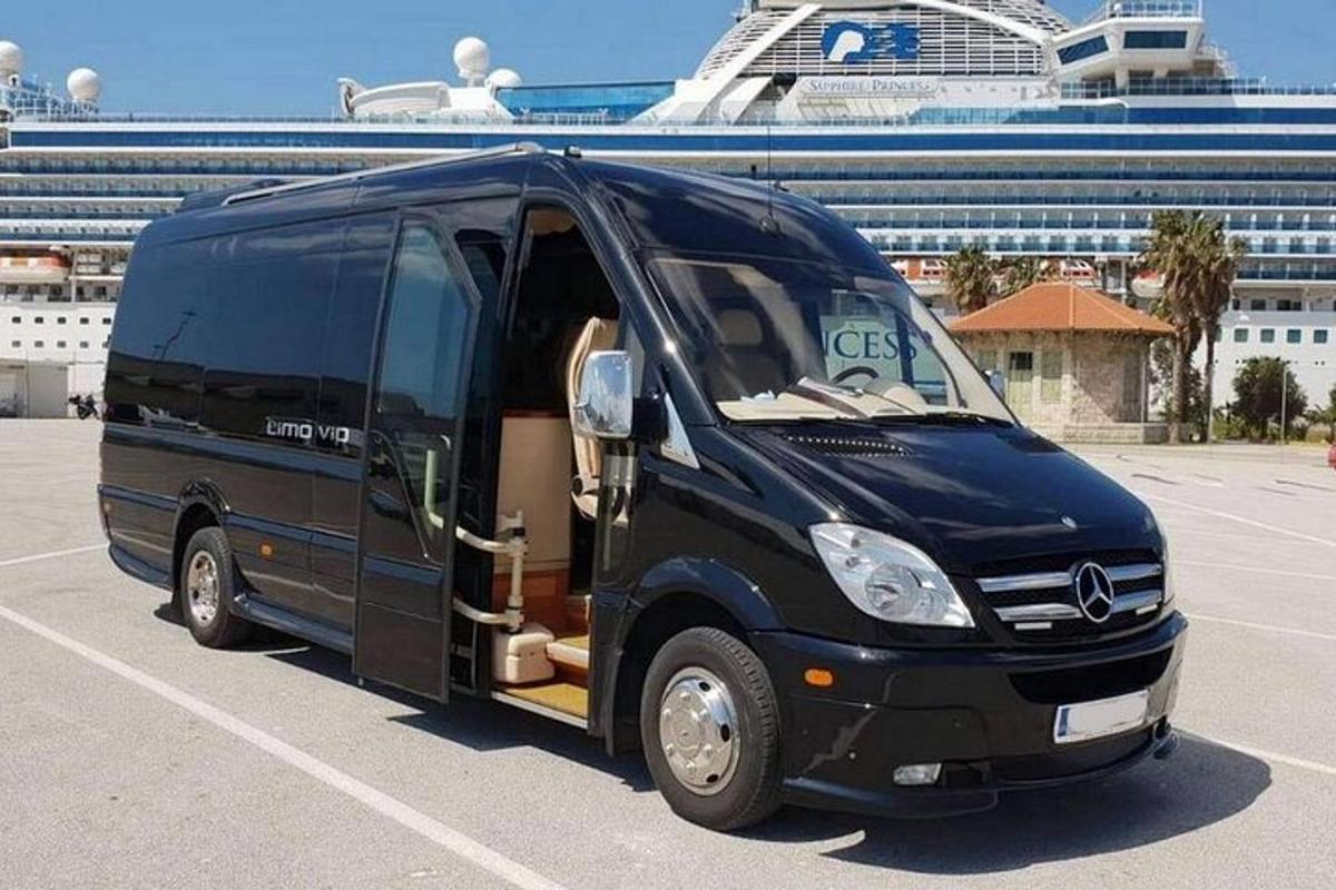 un autobus nero parcheggiato in un parcheggio con una nave da crociera