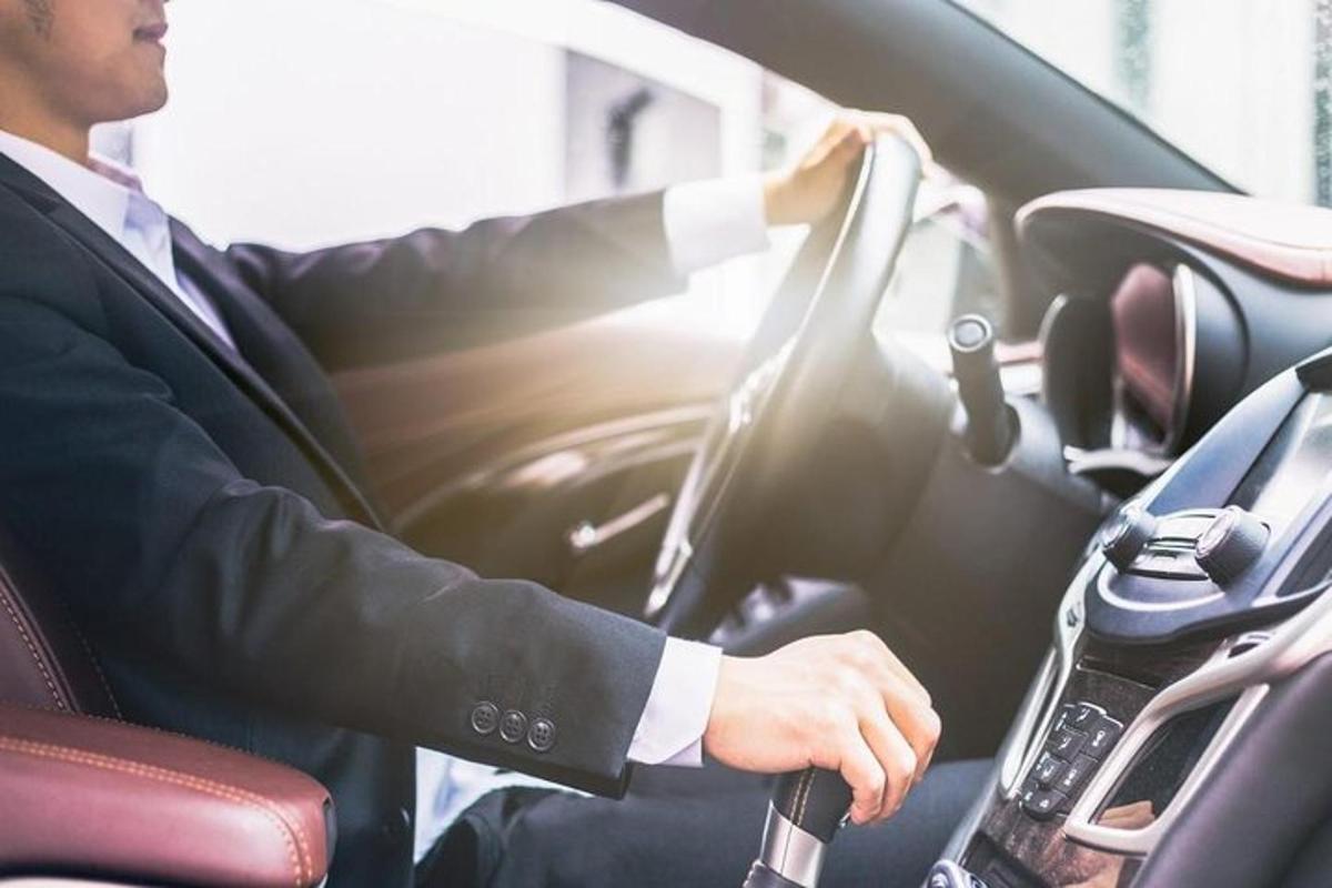 muž v obleku řídící auto
