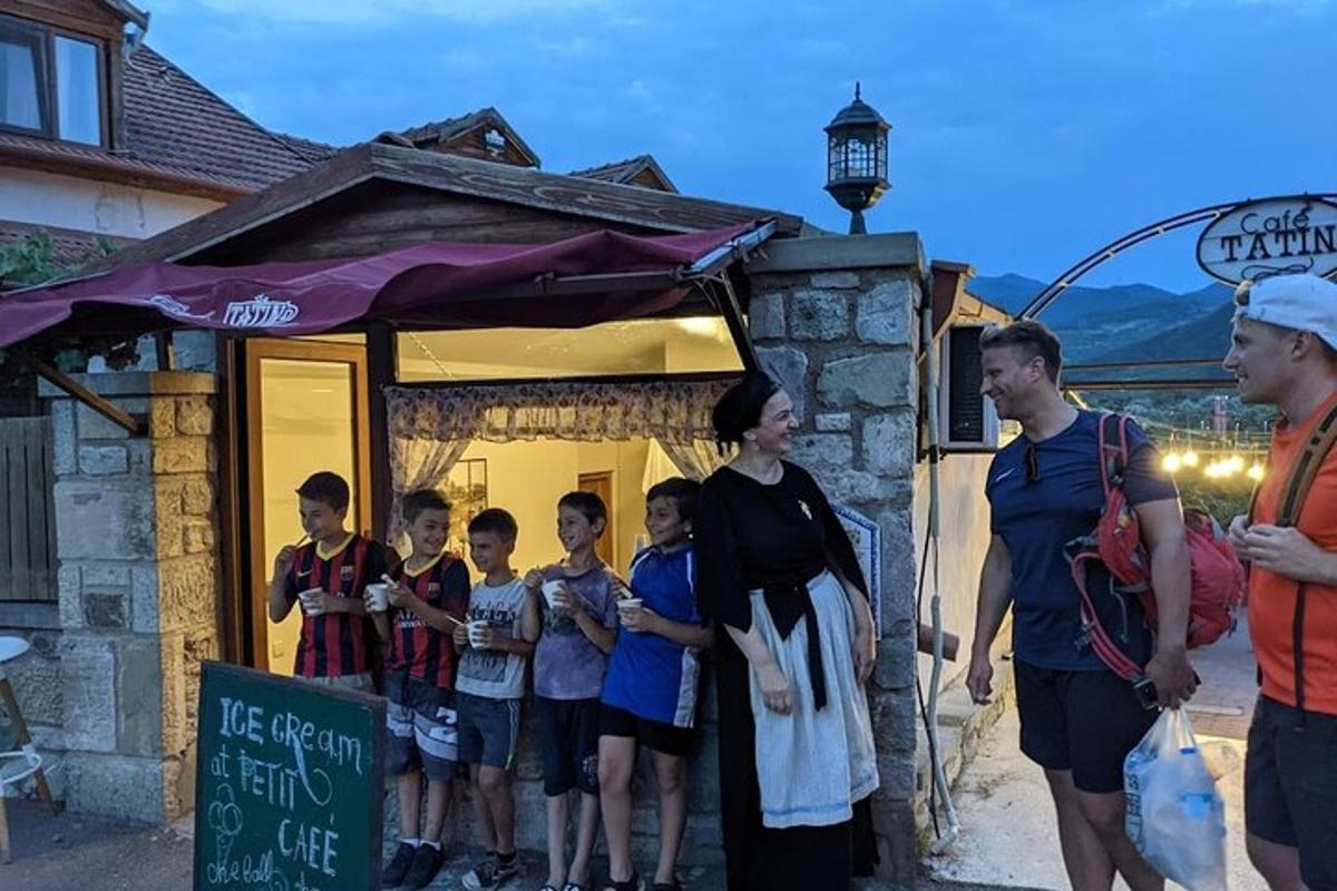 skupina lidí stojící před malou budovou