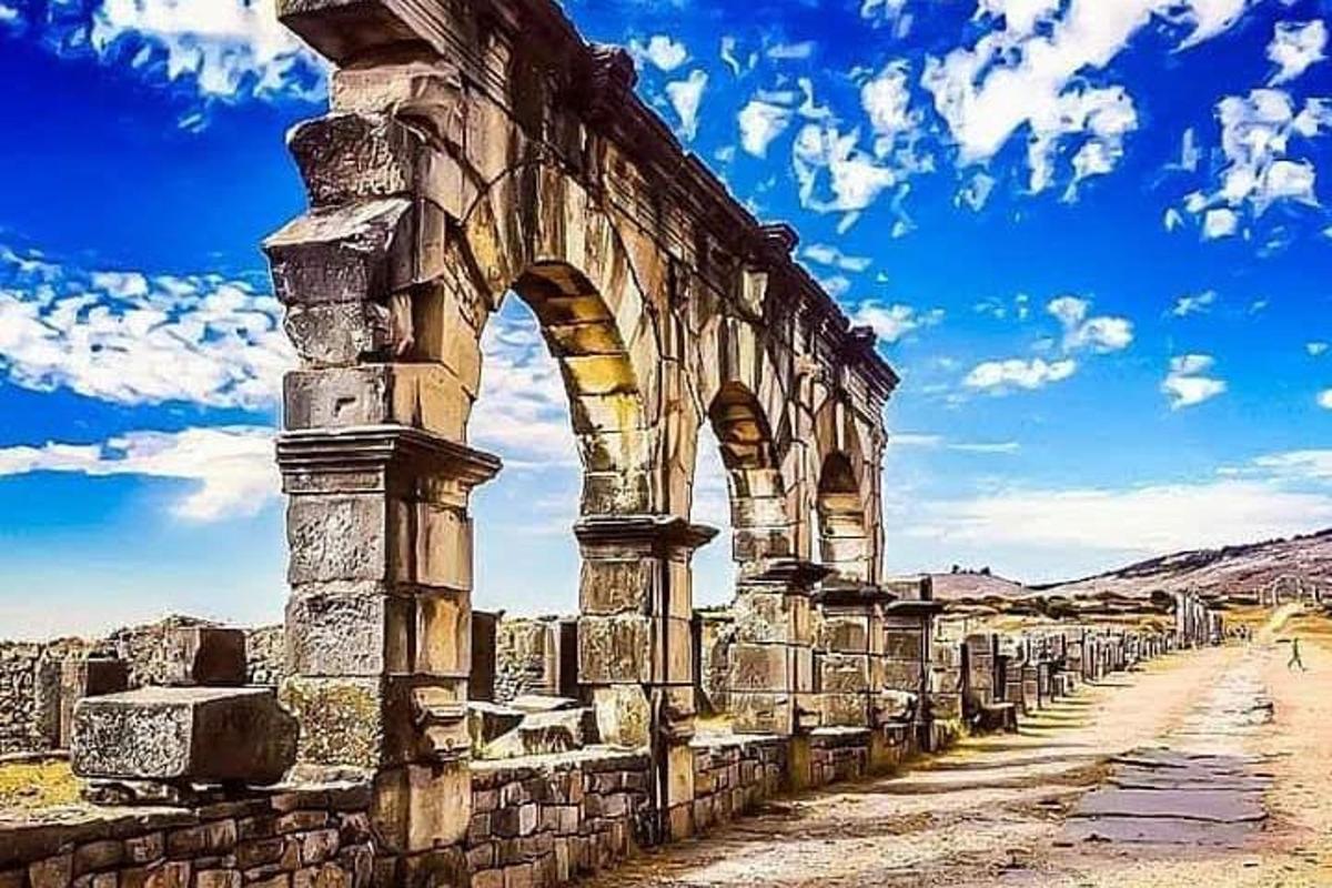 un antico edificio con un arco nel deserto