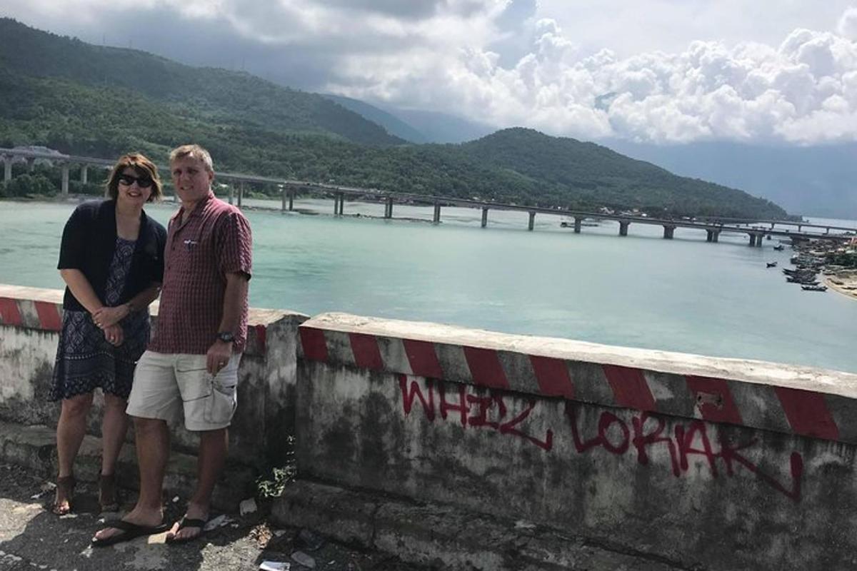 a man and woman standing on a wall next to a river