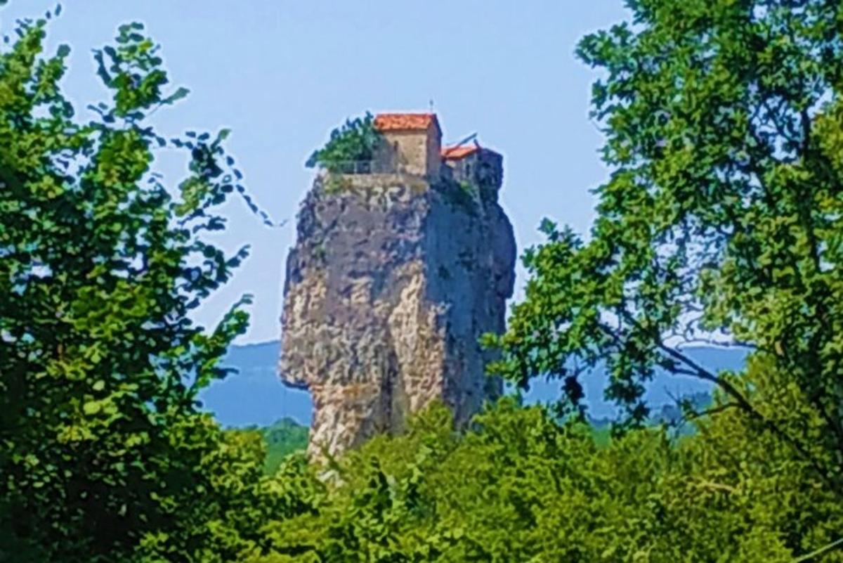 un edificio in cima a una roccia tra gli alberi