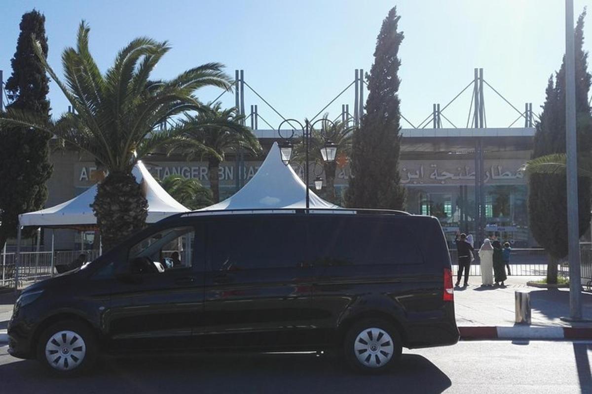 un furgone nero parcheggiato in un parcheggio con una tenda bianca