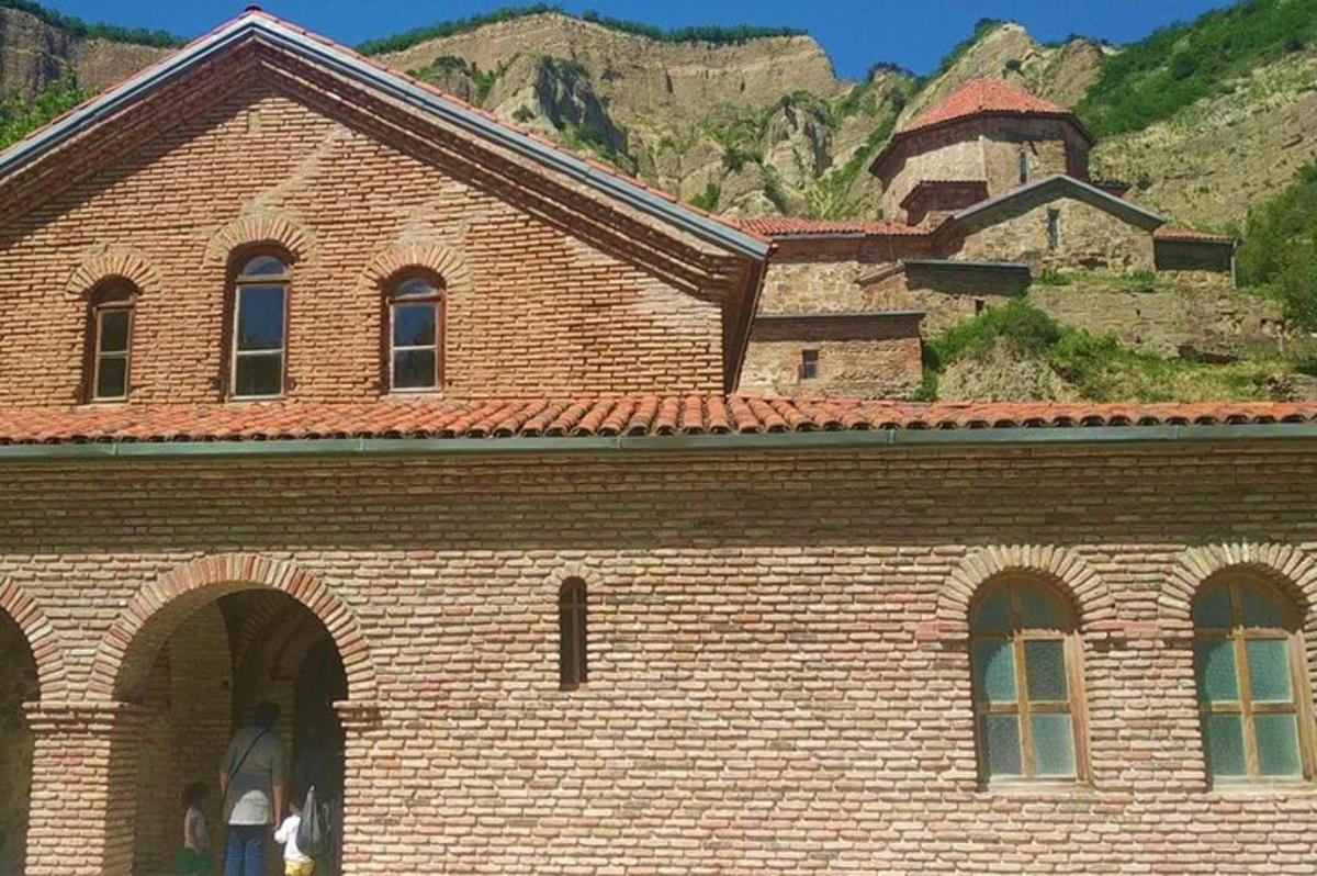 Un gran edificio de ladrillo con una montaña al fondo.