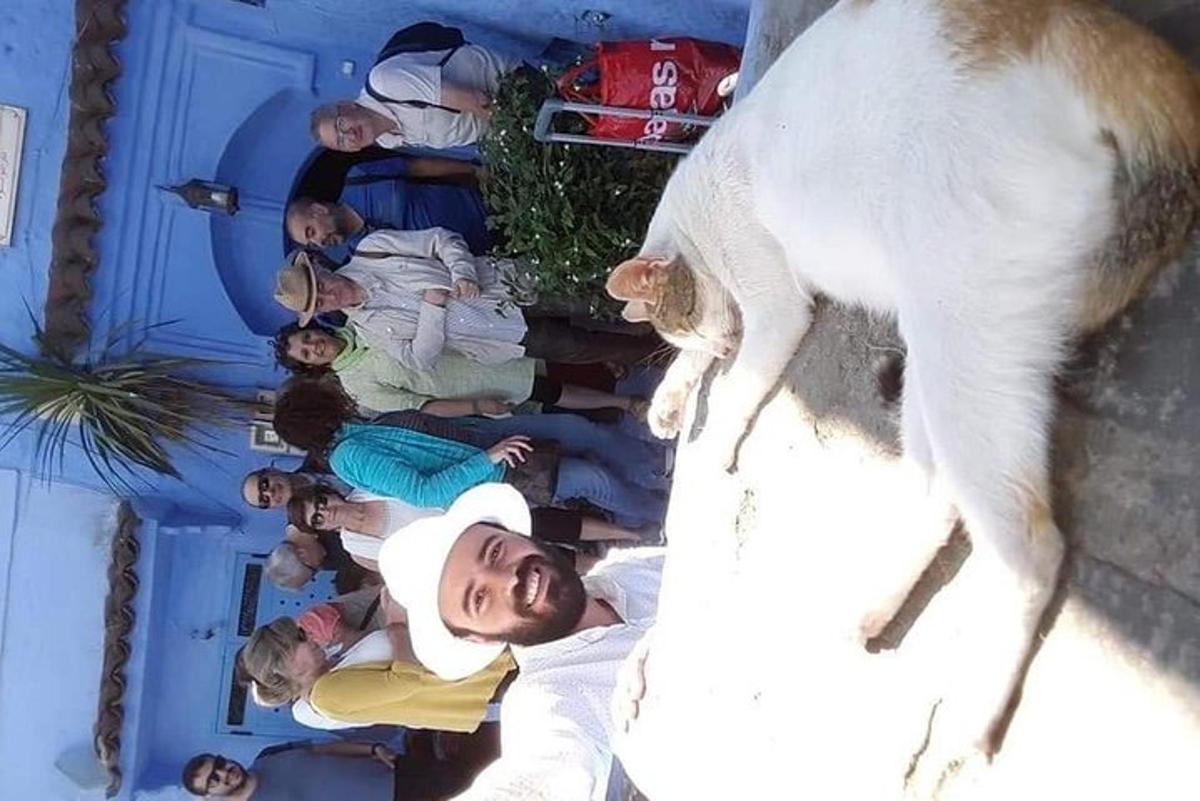 un gruppo di persone in piedi accanto a un gatto