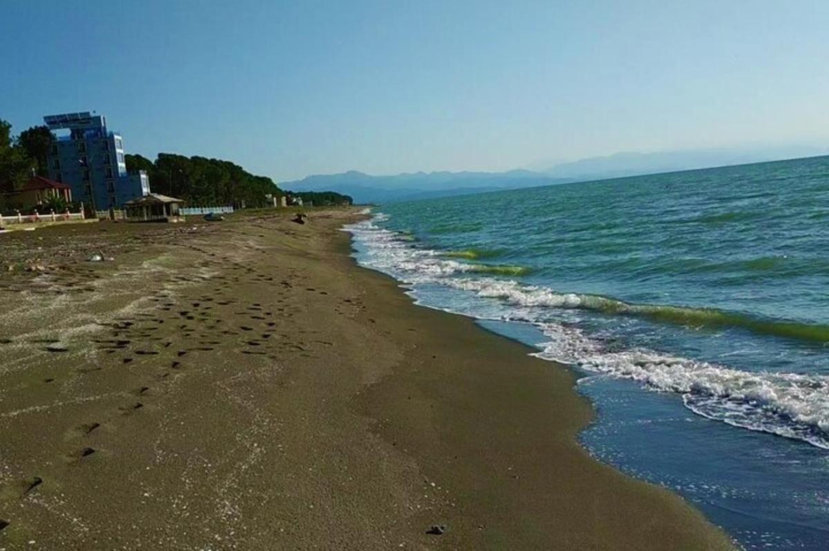 a beach with footprints in the sand and water