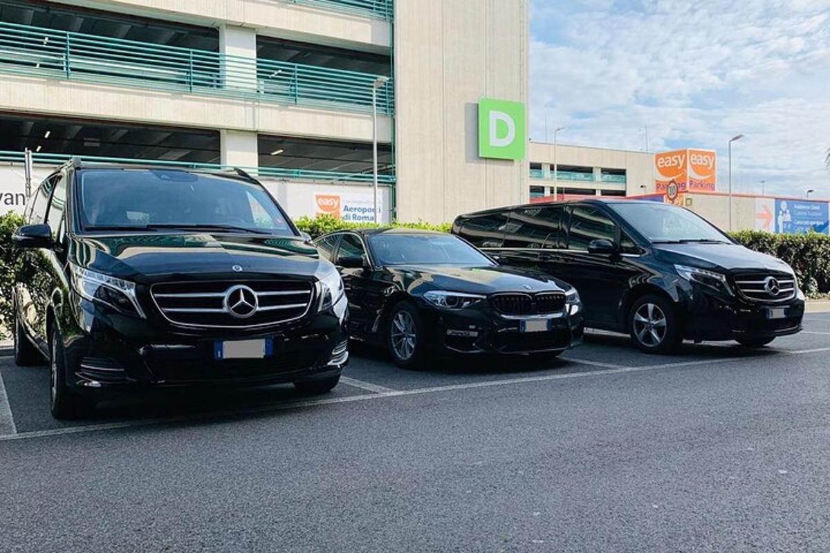 tiga buah kereta diletakkan di tempat letak kereta di hadapan sebuah bangunan