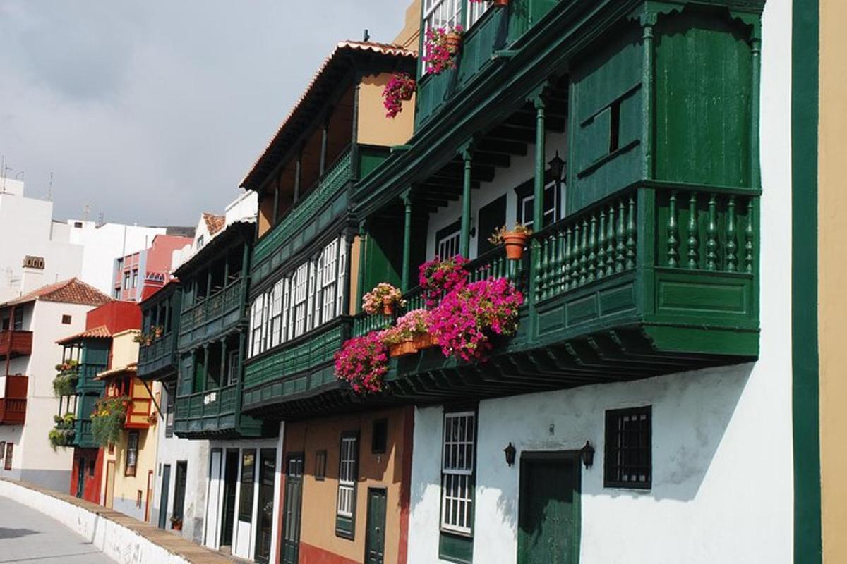 a building with balconies and flowers on a street