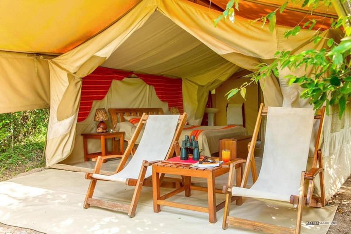 a tent with two chairs and a table in front of it