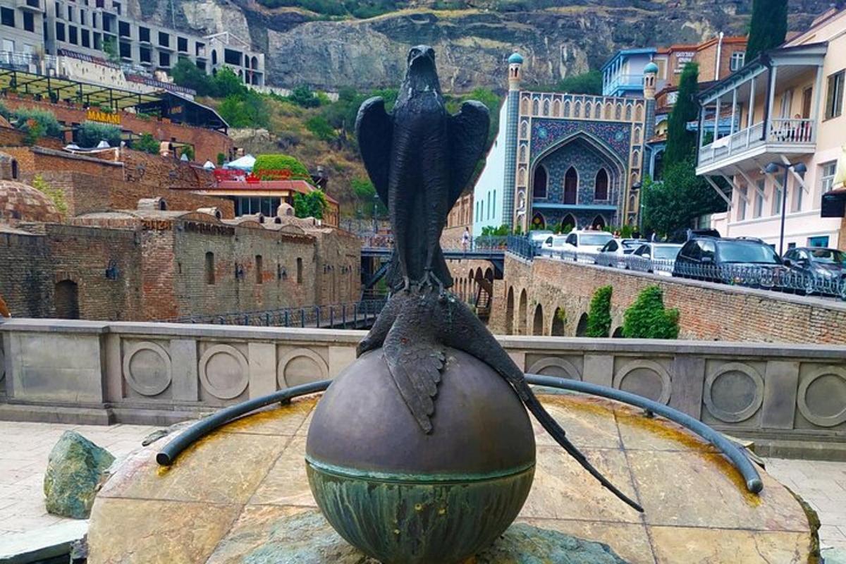 o statuie a unei păsări așezate deasupra unei mingi