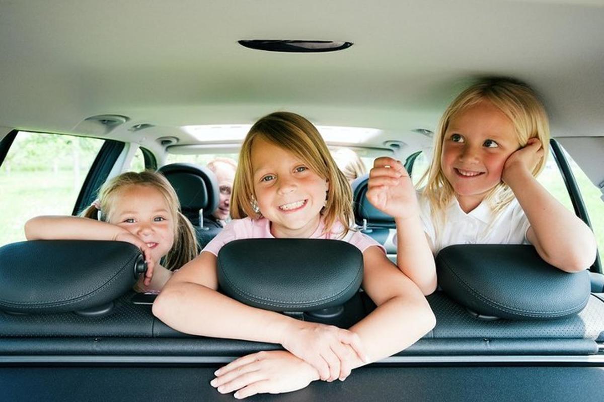 three girls sitting in the back seat of a car