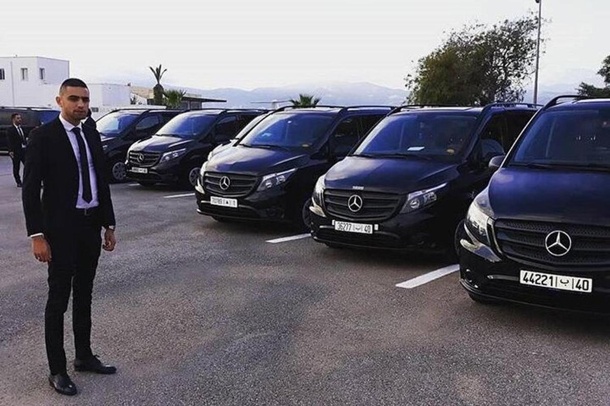 Ein Mann im Anzug steht auf einem Parkplatz