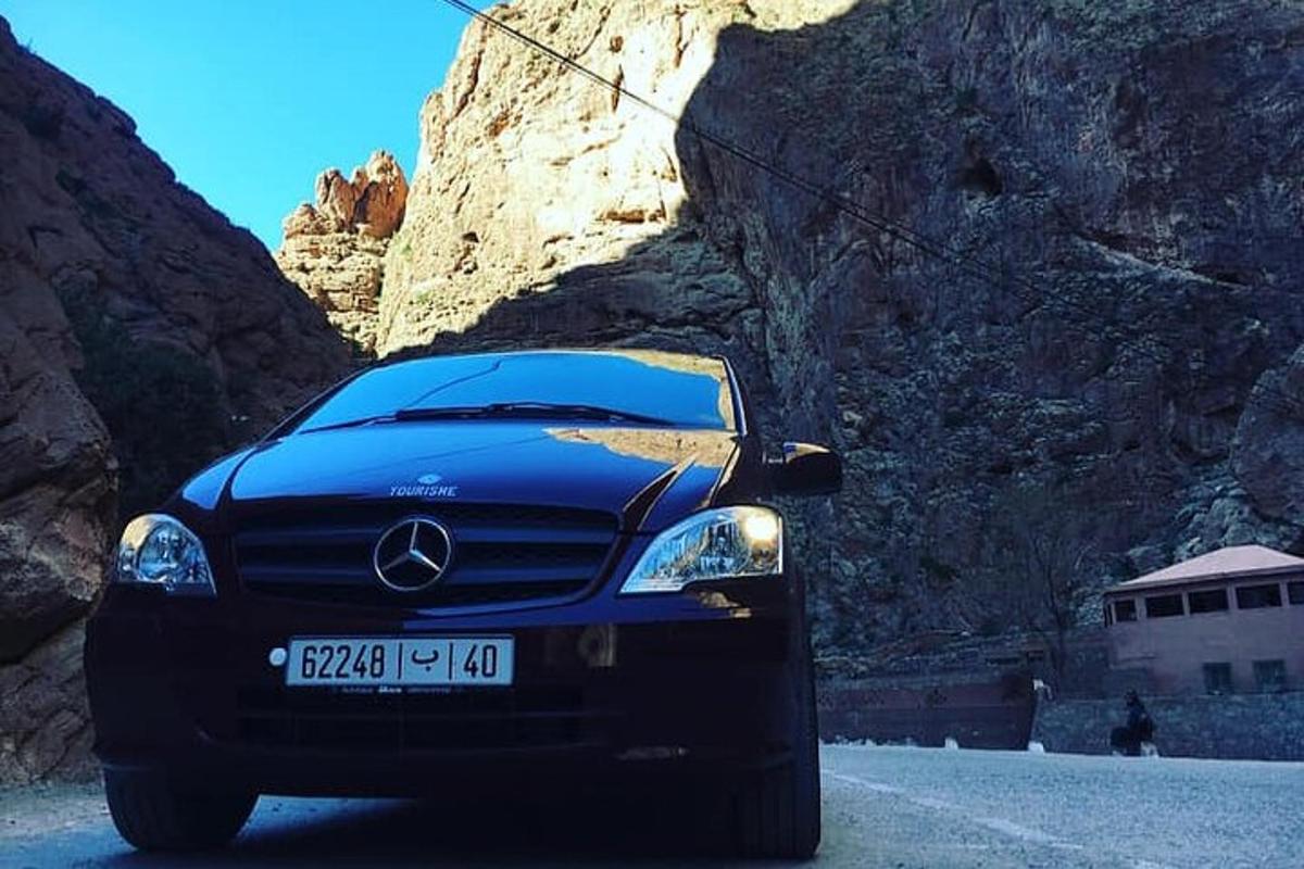 ein blaues Auto, das vor einem Berg geparkt ist