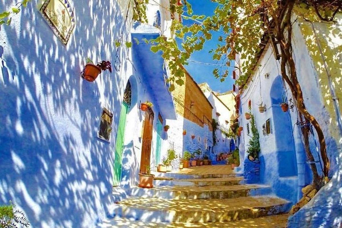 Una pintura de un edificio azul y blanco con escaleras.