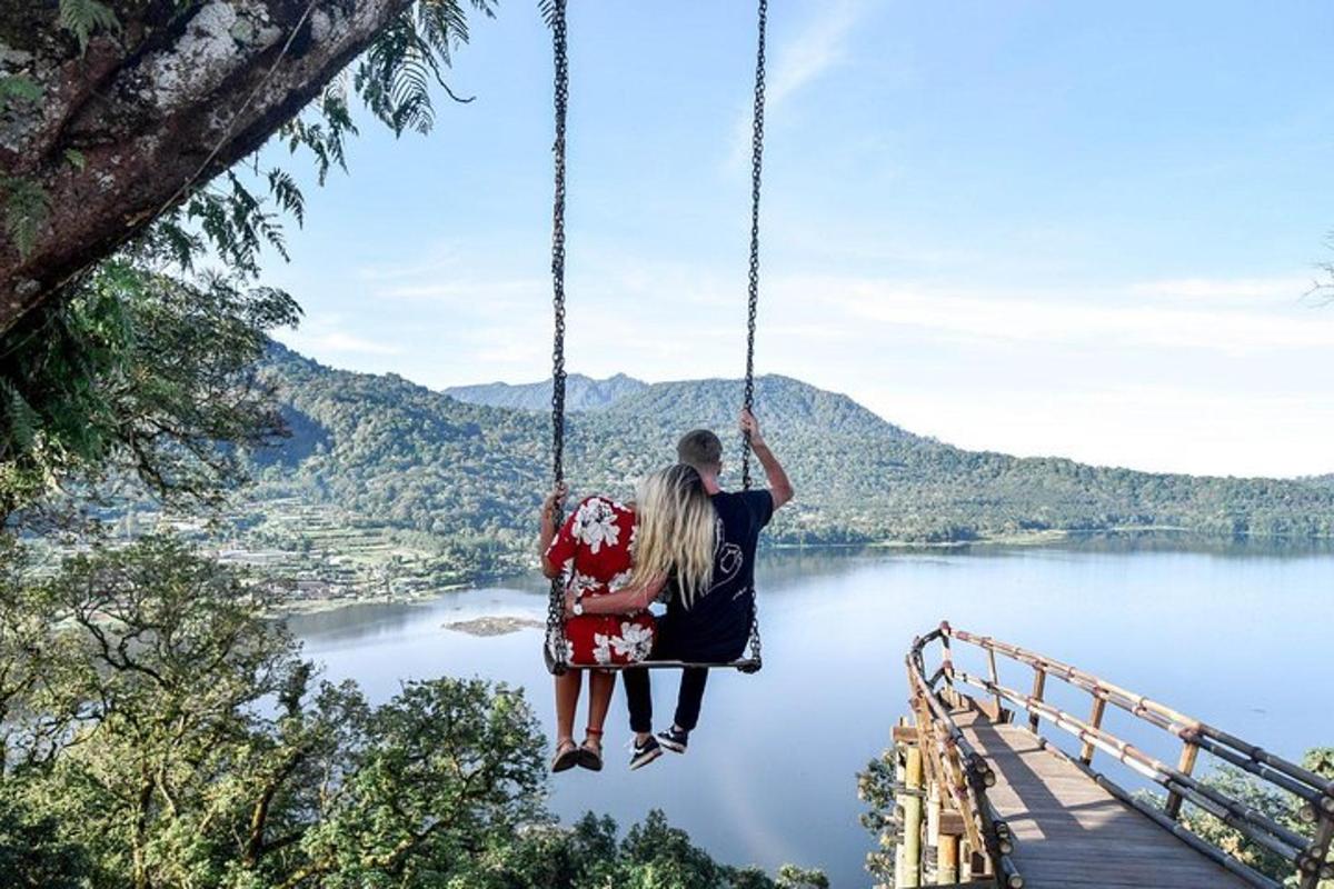 una coppia seduta su un'altalena con vista sul lago