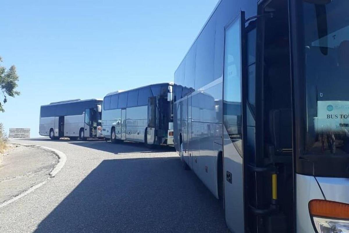 tři autobusy stojí na kraji silnice