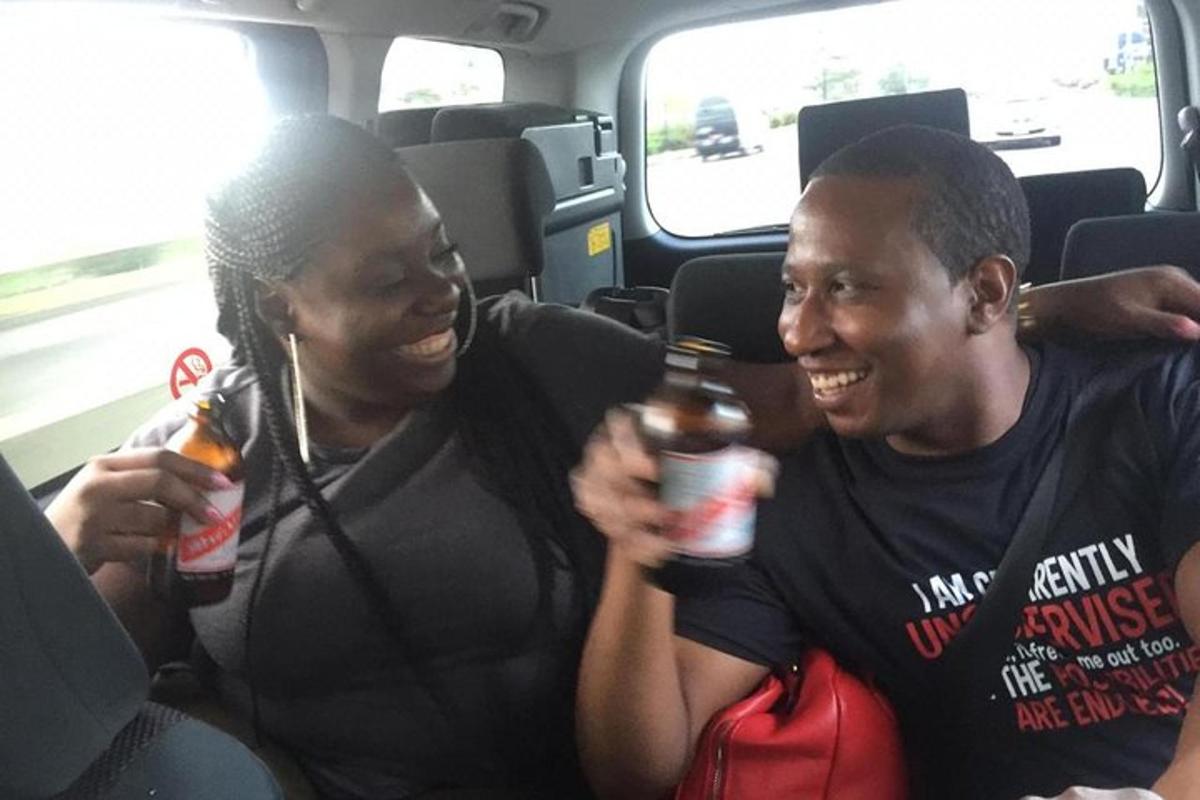 two people sitting on a bus holding drinks