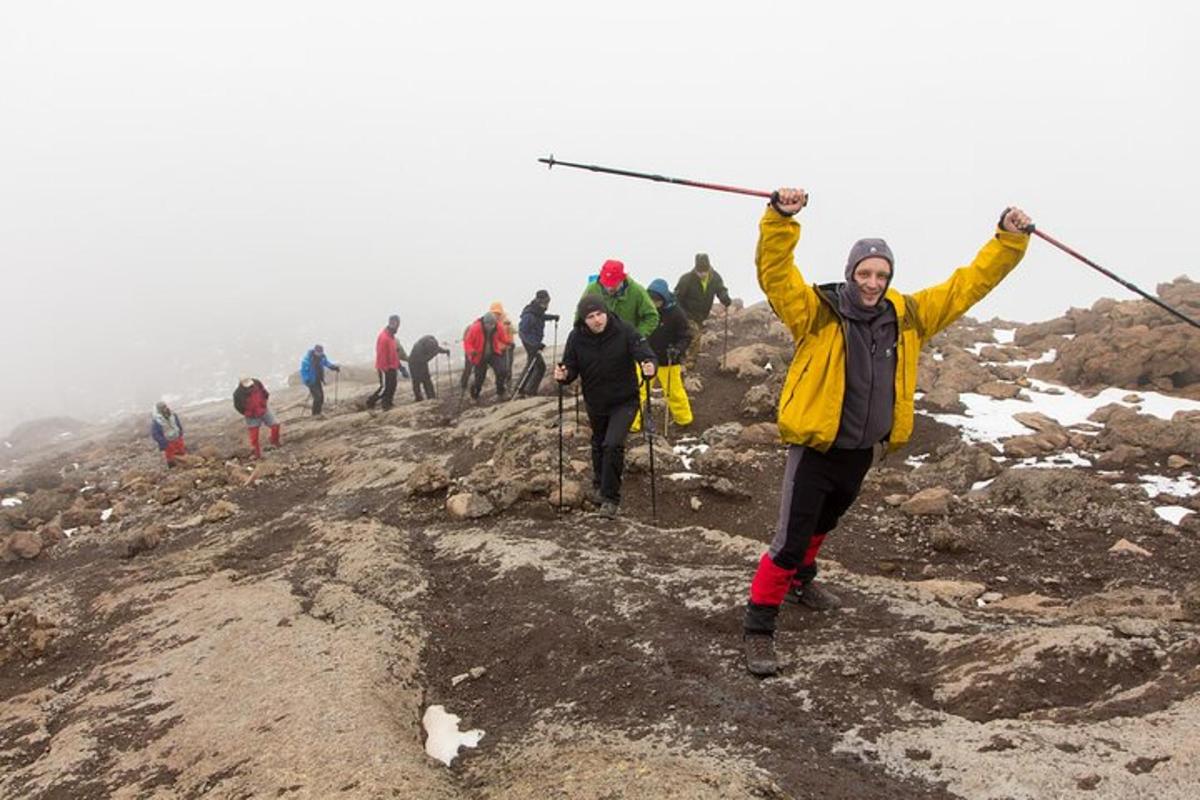 un gruppo di persone su una montagna con le braccia alzate