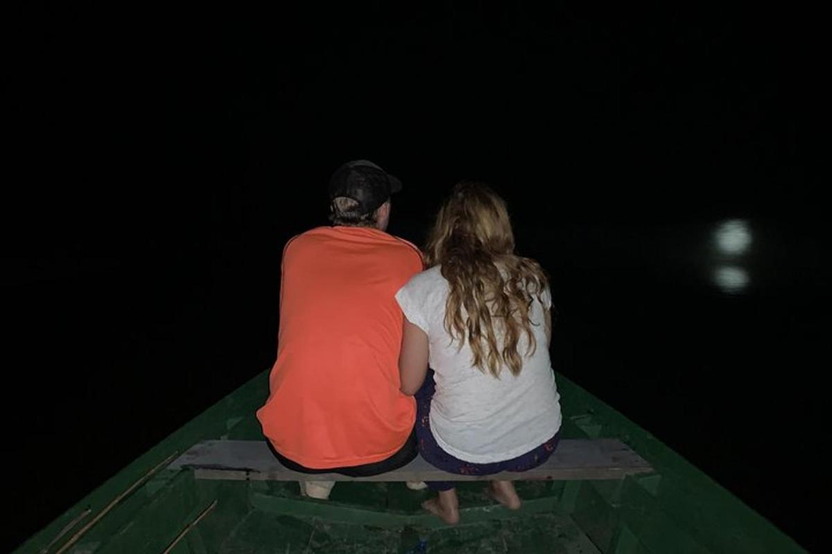a man and woman sitting on the back of a boat