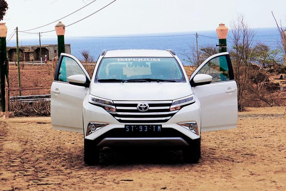 a white car with its doors open on a dirt road