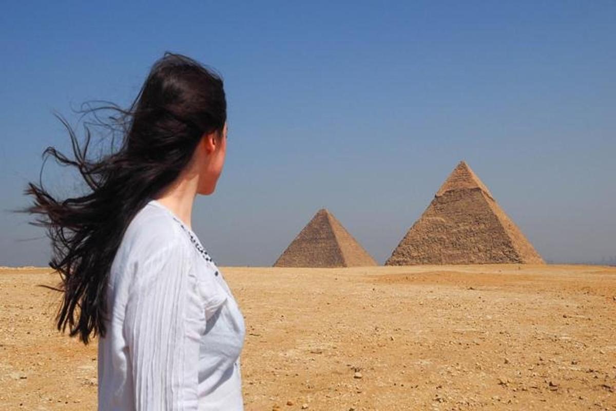 žena stojící před pyramidami