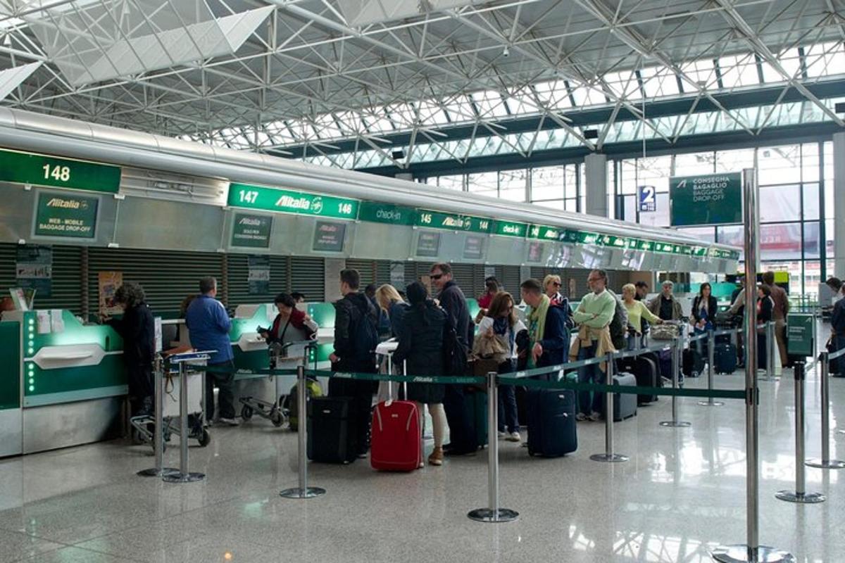 một nhóm người đang chờ hành lý của họ tại sân bay