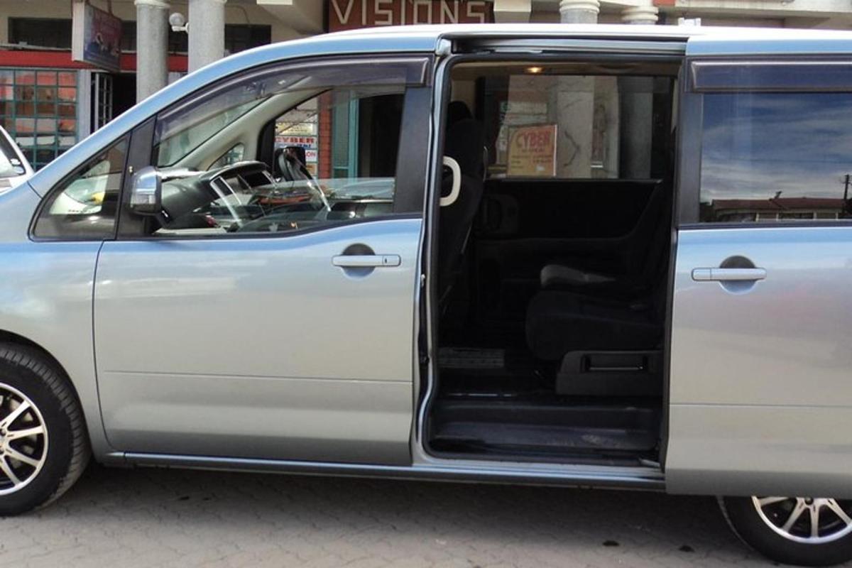 sebuah mobil van berwarna perak dengan pintu terbuka di jalan