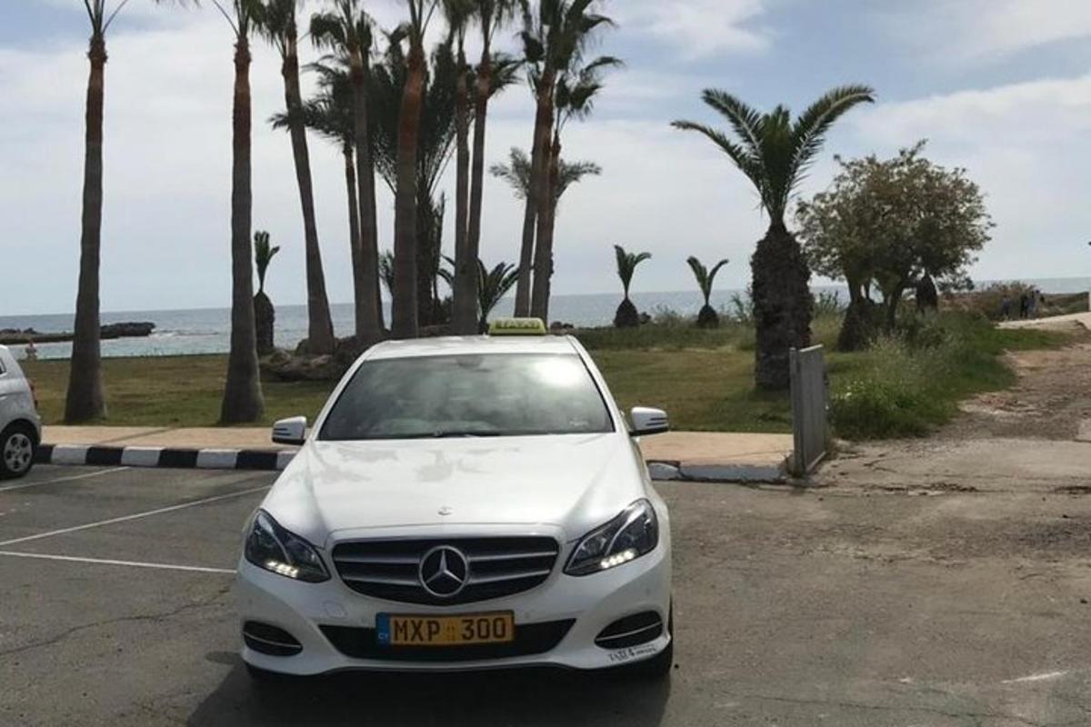 a white car parked in a parking lot near the ocean