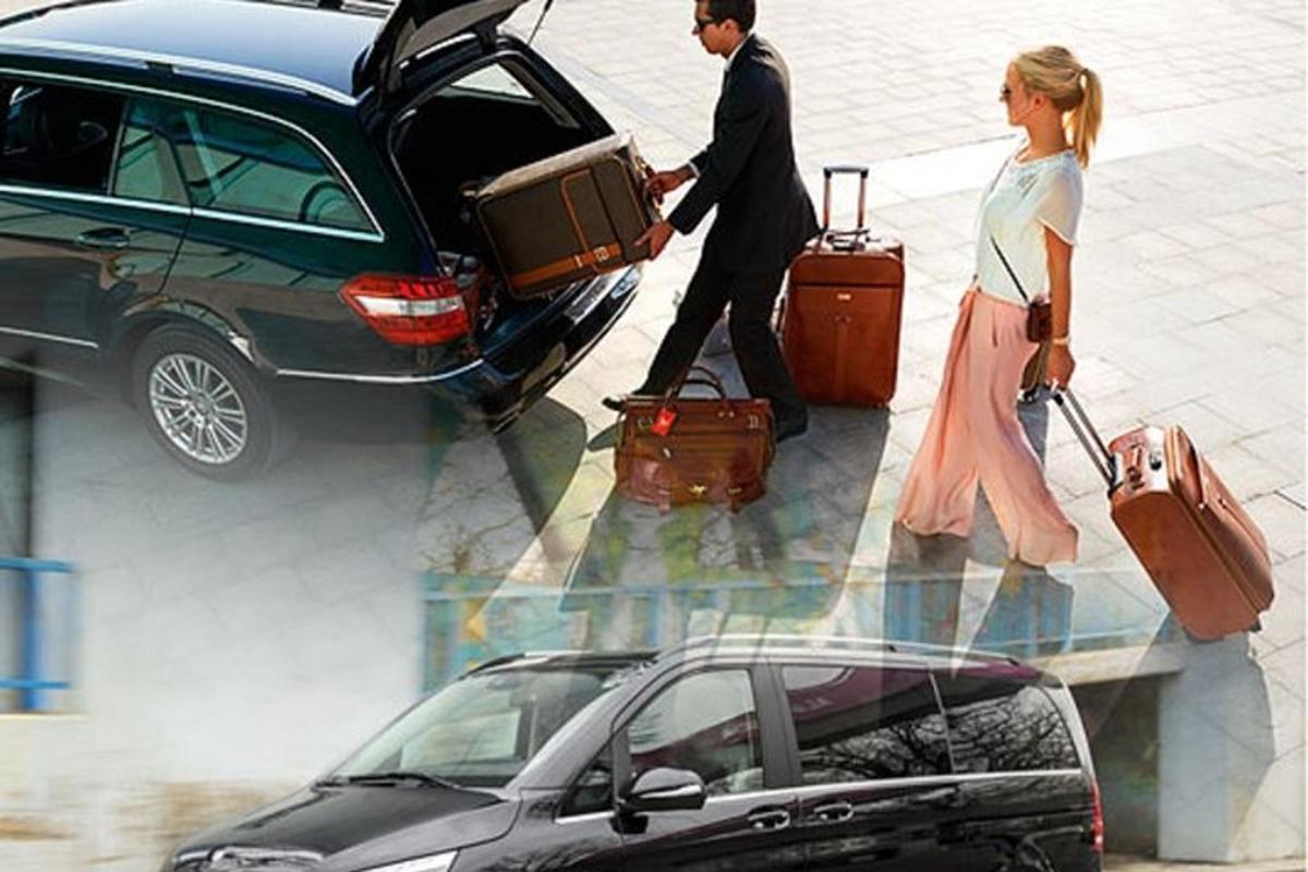a man and a woman pulling luggage out of a car