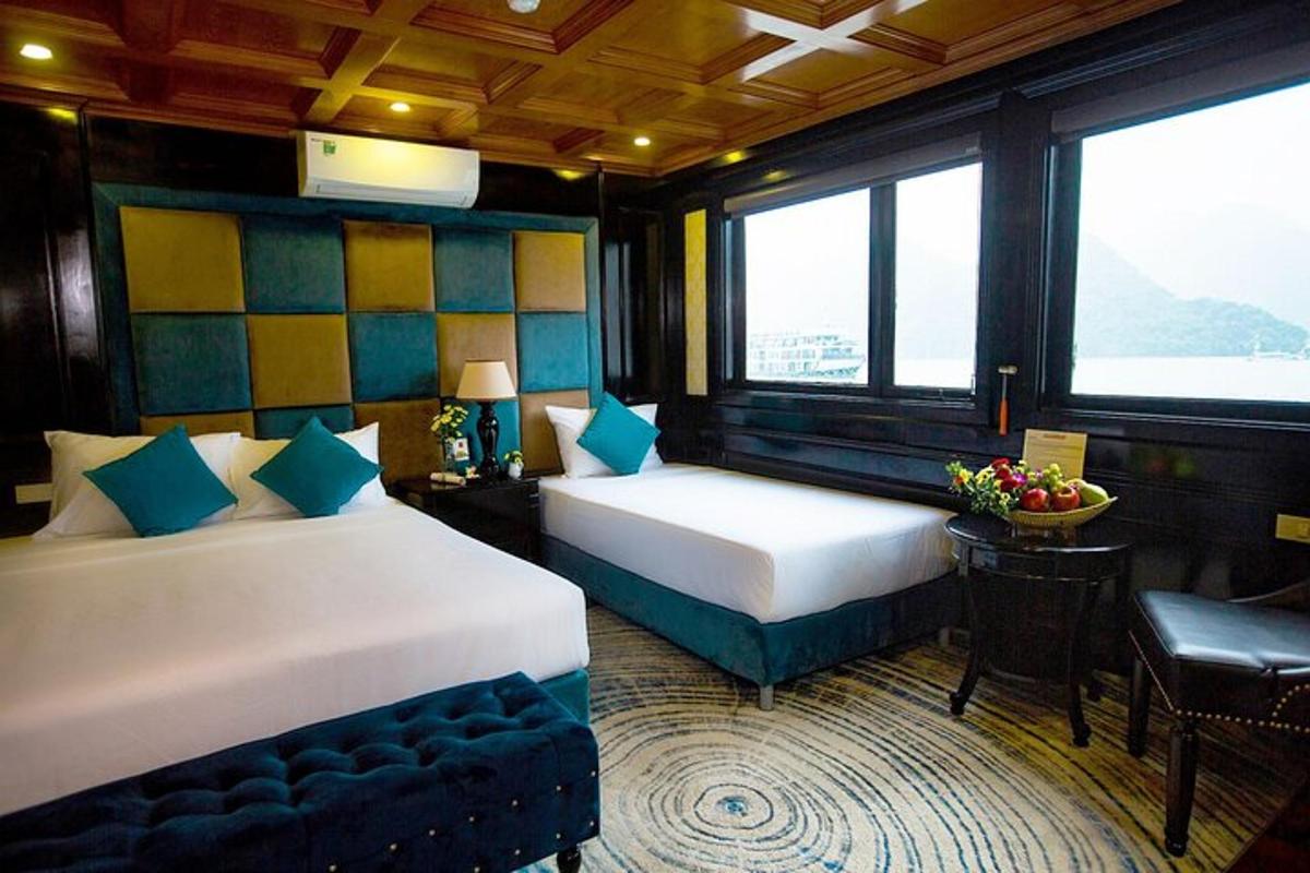 iki yataklı, masa ve sandalyeli bir otel odası