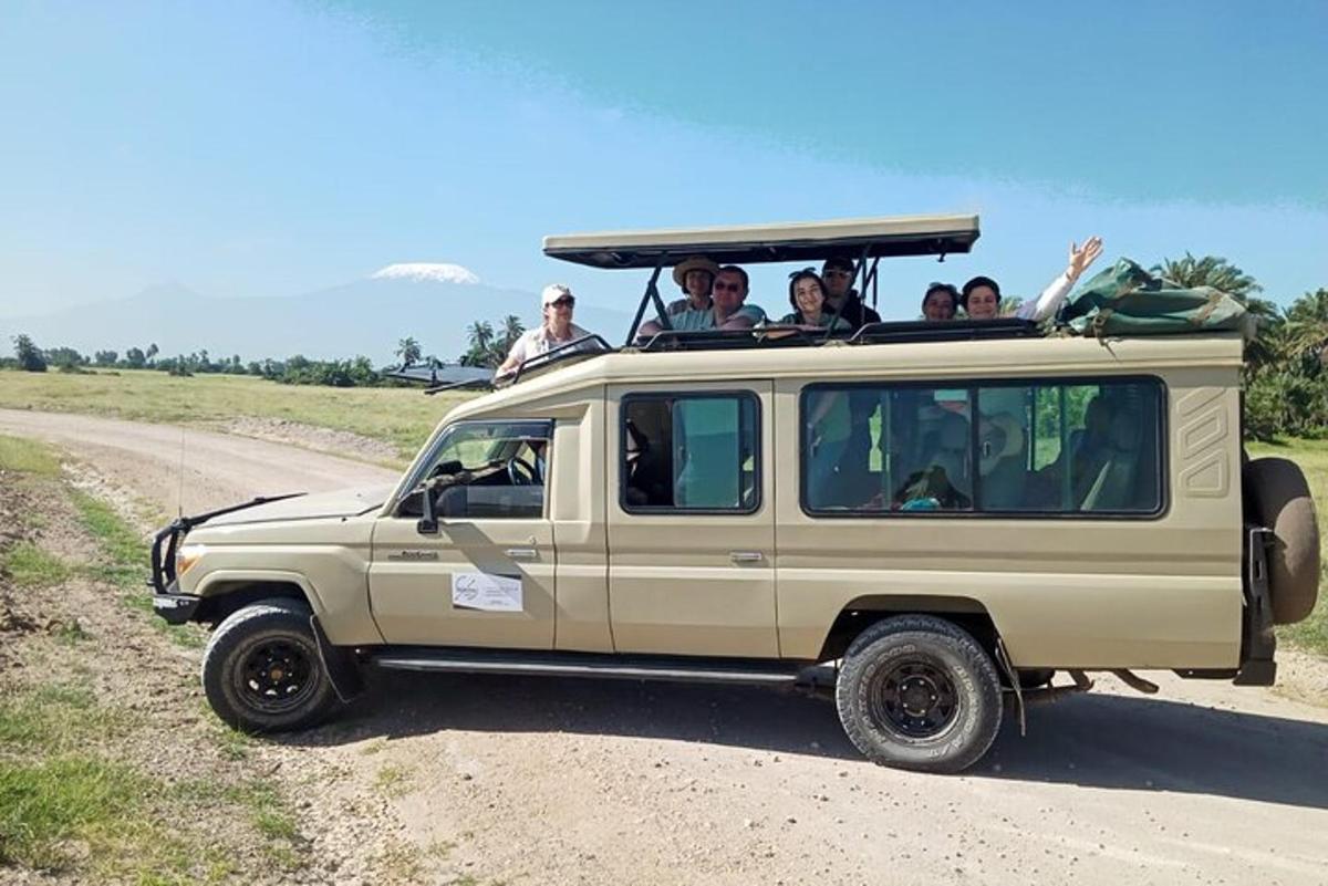 um grupo de pessoas andando de jipe em uma estrada de terra