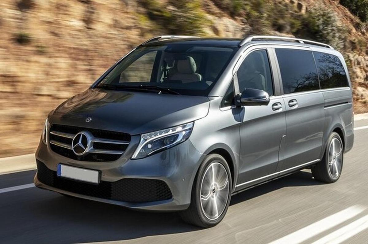 ein silberner Mercedes-Benz Minivan fährt eine Straße entlang