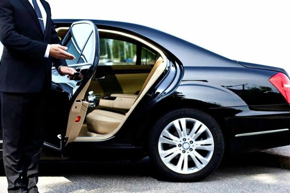 a man opening the door of a black car