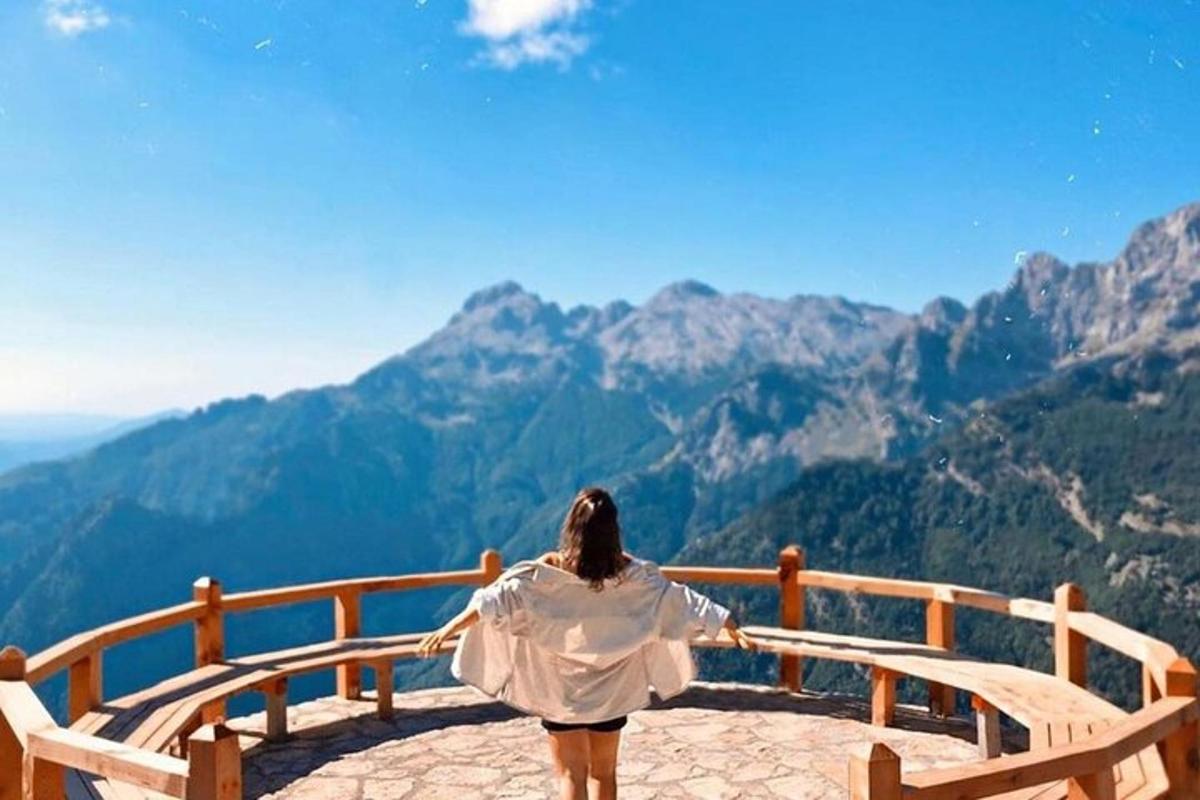 žena sedící na lavičce a dívající se na hory