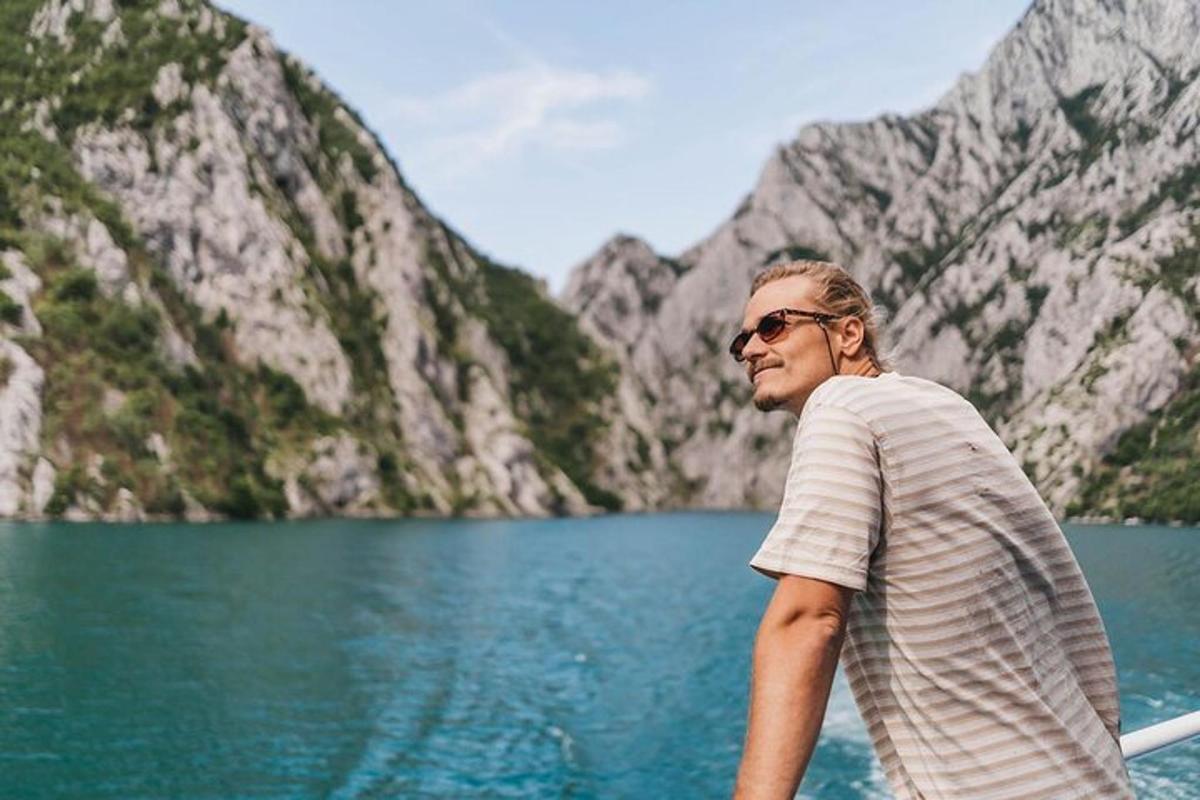 muž stojící na lodi před jezerem