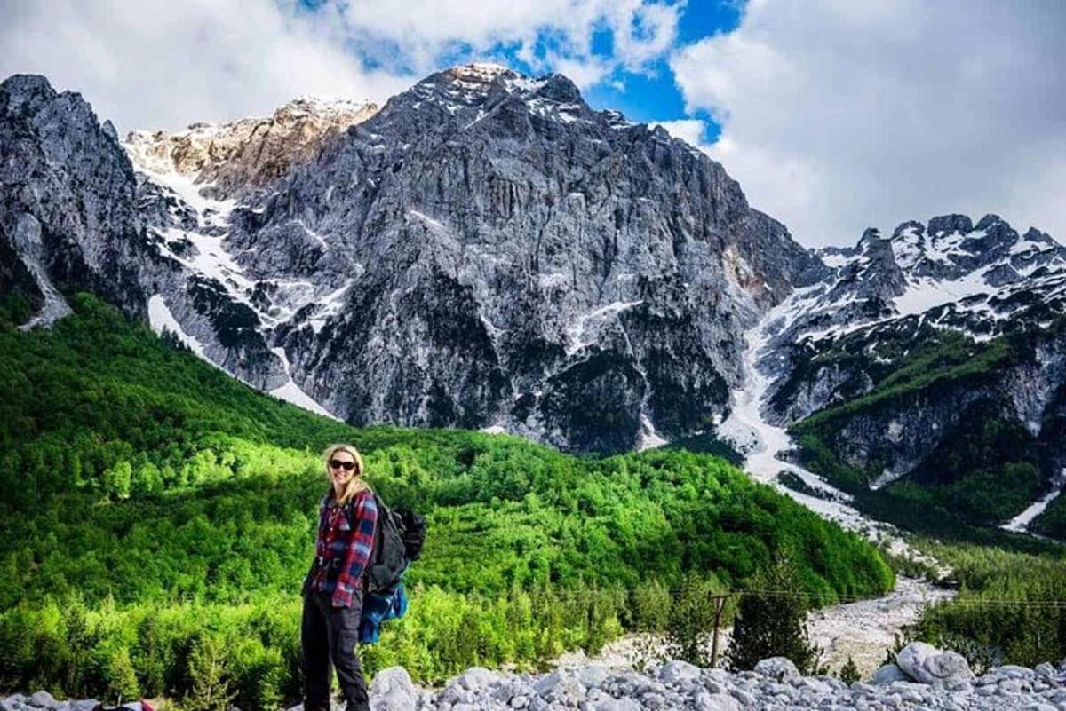 seorang wanita berdiri di depan gunung