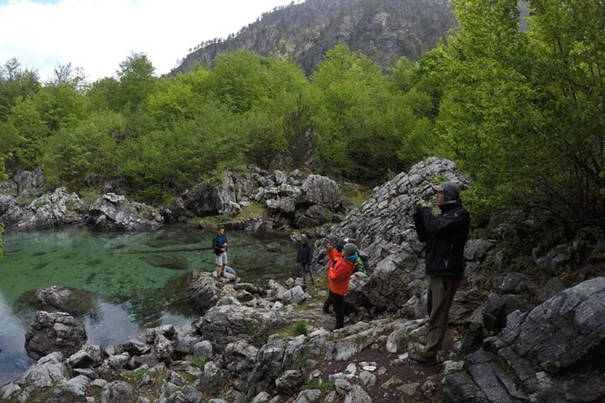 skupina ljudi, ki stojijo na skalah blizu reke