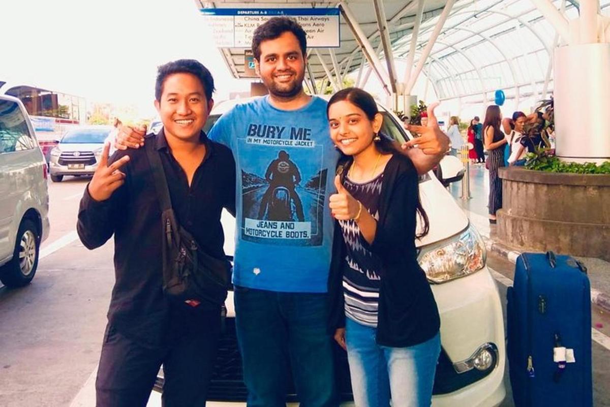 a group of three people standing next to a car