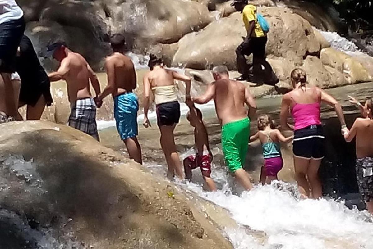 un grup de persones dempeus sobre les roques a l'aigua