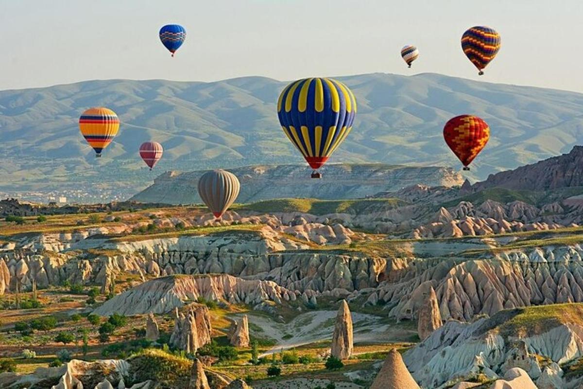un gruppo di mongolfiere che volano sopra le montagne